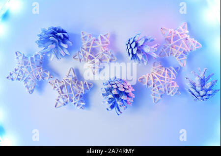 Christmas stars and cones with lights on white background, the New year concept. toned in neon colors Stock Photo