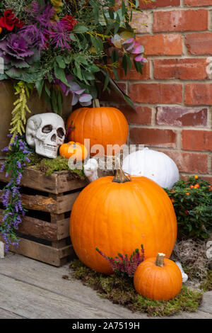 A Halloween display on a porch with pumpkins and skulls Stock Photo