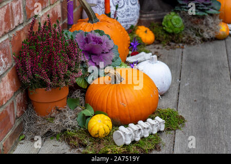 A Halloween display on a porch with pumpkins and skulls Stock Photo
