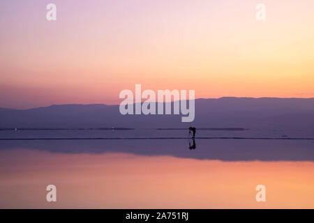 Photographer taking pictures of sunrise on the shore of the Dead Sea. Israel Stock Photo