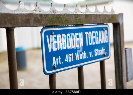Blue No Trespassing sign on rusty fence with Dutch text Verboden Toegang Stock Photo