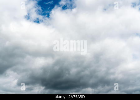 stormy cloudy sky with patches of blue and white clouds horizontal background Stock Photo