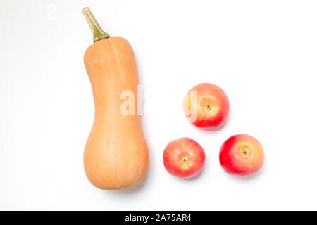 One pumpkin and three apples on a white background. Ingredients for diet salad or freshly squeezed juice. Stock Photo