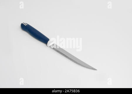 Kitchen utensils - a universal knife with a saw on a light background. Cooking tools. Stock Photo