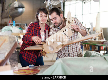 Team of aircraft enthusiasts working in workshop on creating of airplane models Stock Photo