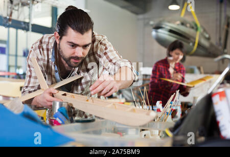Fine male aircraft enthusiast working in workshop on creating of airplane models Stock Photo