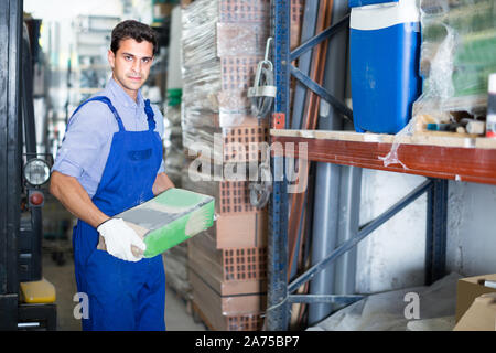 Seller is checking bags with cement in the building store. Stock Photo