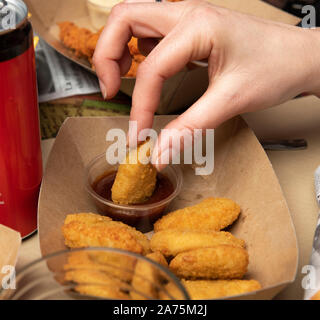 Woman eating chicken nuggets in a restaurant Stock Photo