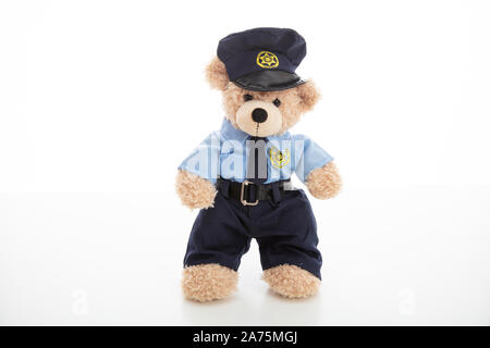 Police and security concept. Cute teddy bear in police officer uniform standing isolated against white background Stock Photo