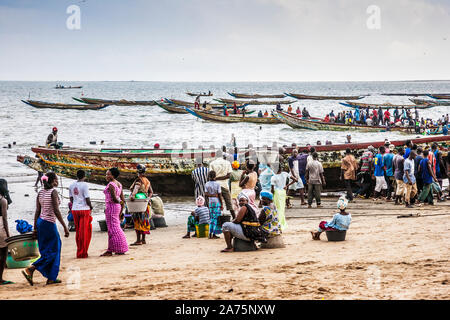 Traditional pirogues or Gambian fishing boats return with their catch to Tanji Fishing Village in The Gambia. Stock Photo