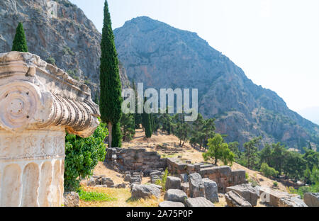 Delphi Greece - July 28 2019; Ancient city on slope of Mount Parnassus focus on top of pillara and architectural capital in ruins and diggings with pi Stock Photo