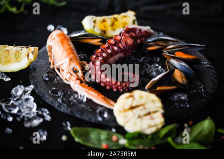 fresh seafood with grilled lemon & garlic - octopus, shrimps, squid, shells Stock Photo