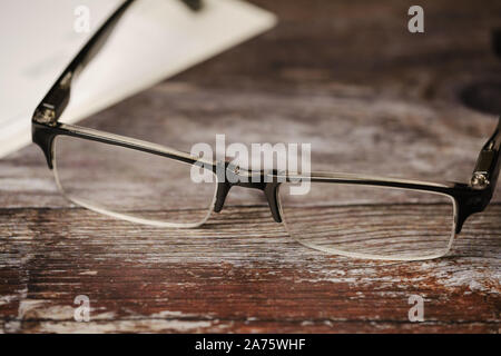 close up of reading glasses on wooden background Stock Photo