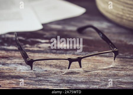 reading glasses lying on a wooden background Stock Photo