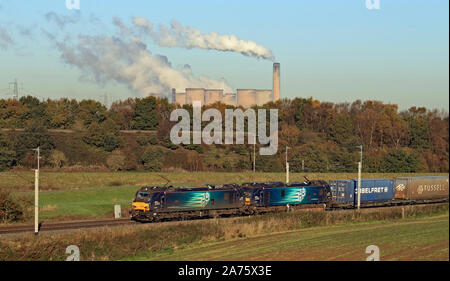 Two DRS locomotive’s pass Daresbury near Runcorn on a bright autumn morning.  The train is carrying intermodal containers from Glasgow to Daventry Stock Photo