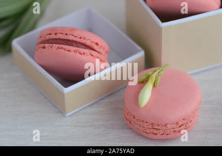 Close up of  raspberrymacarons in the gift box on wooden background. French dessert macaroons  for best present or surprise. Stock Photo