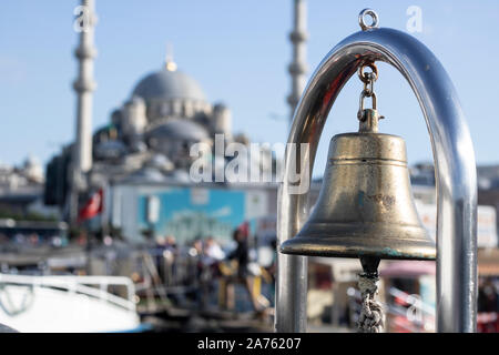 Decorative bells on ship close-up. Image and people on the background of the mosque. Stock Photo