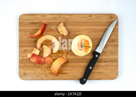 a peeled apple on a wooden board Stock Photo