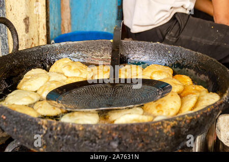 Kachori deep frying in a large black cast iron pan filled on the streets of Jodhpur, Rajasthan state, India Stock Photo