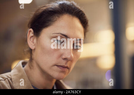 Close-up of mature serious woman with brown hair and green eyes thinking about something Stock Photo