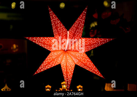 Evening shop window with a lit up Christmas star as decoration in a small shop on the island Usedom in Germany. Stock Photo