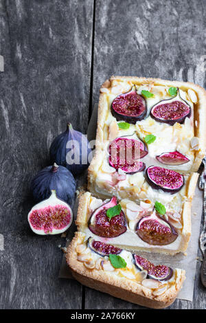 Homemade  fig pie with brie cheese and almonds on wooden table Stock Photo
