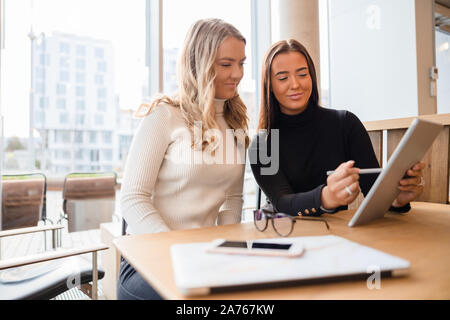 Young Professionals Discussing Over Digital Tablet At Cafe Stock Photo