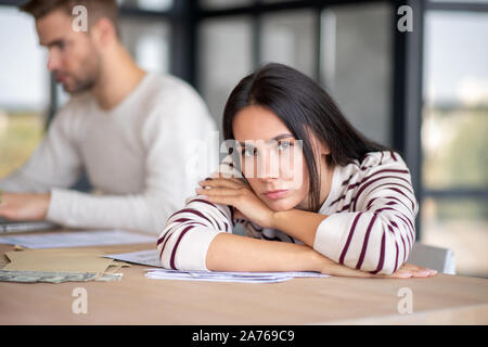 Wife feeling thoughtful while counting money with husband Stock Photo