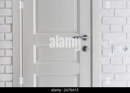 Classic door and wall decorated with decorative brick. White Scandinavian interior Stock Photo