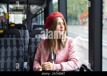 Young woman wearing red beret riding bus Stock Photo