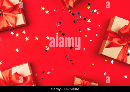 Several gift boxes with bows on a red background. Stock Photo