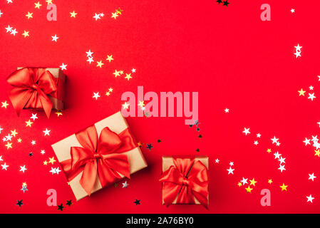 Several gift boxes with bows on a red background. Stock Photo