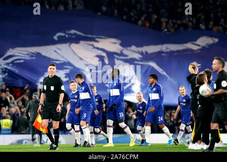 Chelsea players walk out on to the pitch as fans in the stands hold up a banner of Chelsea manager Frank Lampard prior to the beginning of the Carabao Cup, Fourth Round match at Stamford Bridge, London. Stock Photo