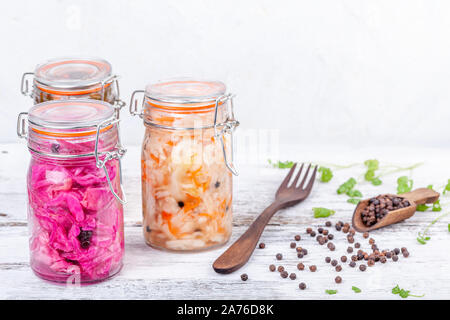 Homemade marinated sauerkraut sour in glass jars on rustic wooden kitchen table Stock Photo