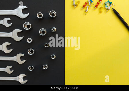 Flat Lay Composition With Different Construction Tools on Black and Yellow Background. Top View of Checklist and Working Tools, Wrench, Screwdriver Stock Photo