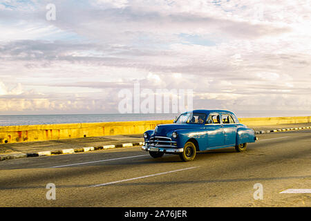 Blue car driving along the Malecon in Havana, Cuba