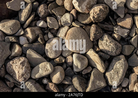 Small stones in different shapes on the shore Stock Photo