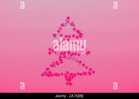 Christmas Tree made from stars on bright pink background Stock Photo