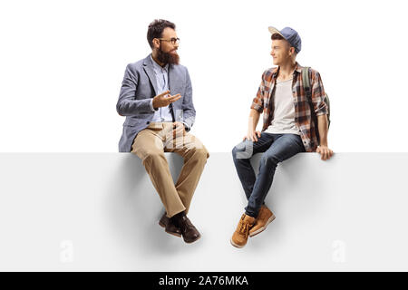 Full length shot of a teacher talking to a male student sitting on a panel isolated on white background Stock Photo