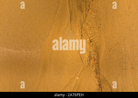 Close-up of sand with tidal ways and shells on the beach, full frame texture Stock Photo