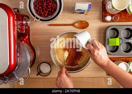 Adding cocoa powder to mixture for muffin making Stock Photo