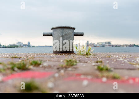 skyline of Amsterdam with a small mooring-mast or bollard or dolphin on the kay wall Stock Photo