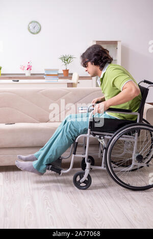 Unhappy male disabled student in a wheelchair isolated on white ...