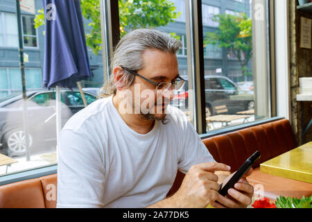 Man looking at his hands with smartphone texting message or dialing in office Stock Photo