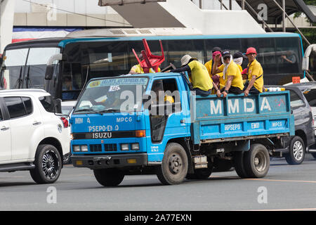 Manila, Philippines - June 7, 2017: Filipino workers ride in the back of a truck Stock Photo