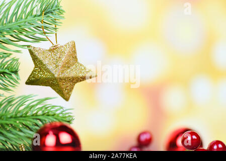 Christmas ball and gold star decoration for pine tree with red balls holiday light gold background / christmas tree festive xmas winter and Happy New Stock Photo
