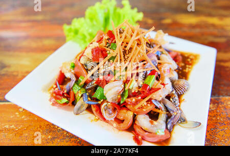 Seafood salad spicy with fresh shrimp crab cockles served on white plate fresh vegetables herbs and spices ingredients with carrot salad lettuce - Som Stock Photo