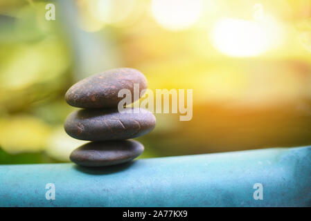 Natural wellness concept / Relax zen stones stack on wooden nature green background Spa Natural Alternative Therapy With Massage Stones Stock Photo