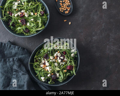 Beetroot, aragula and soft cheese salad over black background. Top view or flat lay. Copy space for text. Idea and recipe for healthy vegetarian salad. Clean eating diet concept Stock Photo