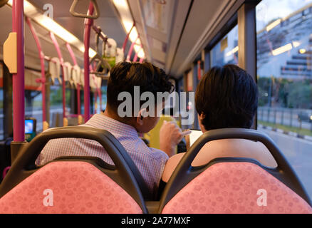 SINGAPORE-08 MAR 2018:couple play smart phone in the bus Stock Photo
